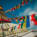 Boudhanath Stupa's golden spire and all-seeing eyes framed by colourful Tibetan prayer flags