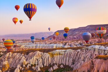 Hot air balloon flying over rock landscape at Cappadocia Turkey
