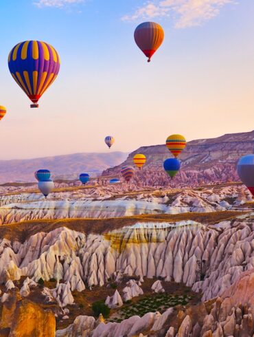 Hot air balloon flying over rock landscape at Cappadocia Turkey