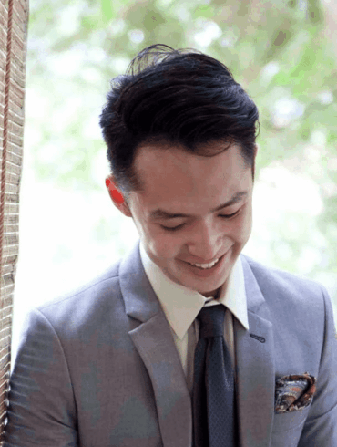 An Asian young adult man dressed in a grey suit