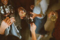 Friends clinking glasses of red and white wine at a casual bar gathering in Singapore