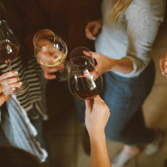 Friends clinking glasses of red and white wine at a casual bar gathering in Singapore