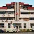Art Deco pre-war shophouse block on Tiong Poh Road in Tiong Bahru, Singapore, with curved red roof and street-level cafes.