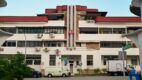 Art Deco pre-war shophouse block on Tiong Poh Road in Tiong Bahru, Singapore, with curved red roof and street-level cafes.
