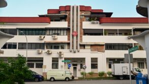 Art Deco pre-war shophouse block on Tiong Poh Road in Tiong Bahru, Singapore, with curved red roof and street-level cafes.