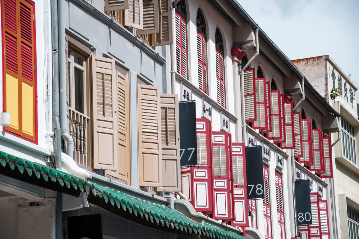 Row of traditional shophouses with open louvered shutters on Amoy Street in Singapore
