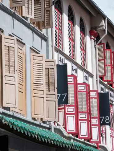 Row of traditional shophouses with open louvered shutters on Amoy Street in Singapore