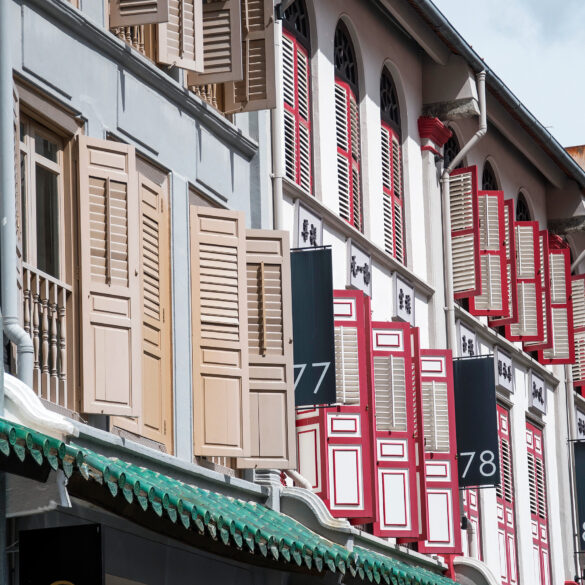 Row of traditional shophouses with open louvered shutters on Amoy Street in Singapore