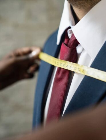 A man having a suit fitted at a tailor