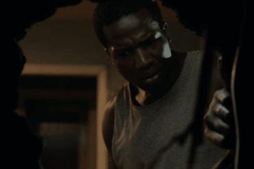 A man peers through a hole in the wall