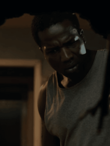 A man peers through a hole in the wall