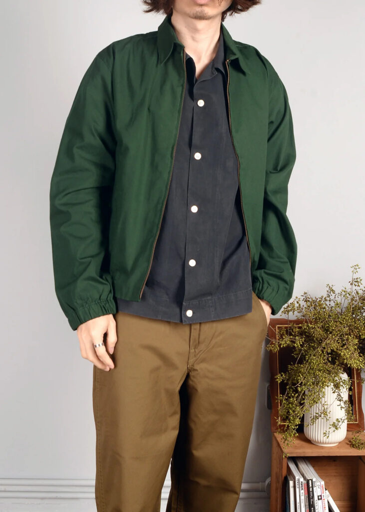 Kerbside & Co. look featuring a green zip-up coach jacket layered over a dark button-up shirt