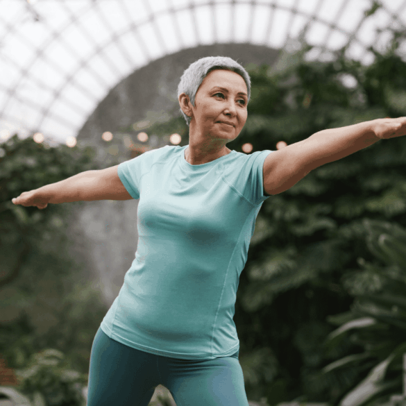 An elderly woman practising self-healing technique like yoga in the park