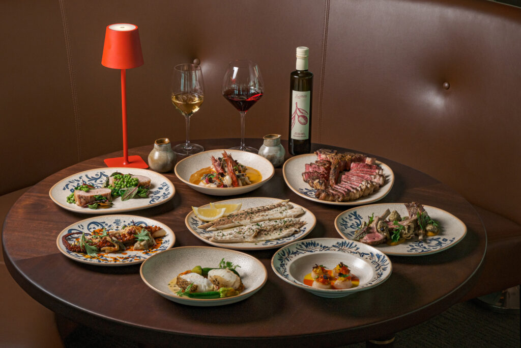 Italian set lunch spread at Altro Zafferano, Singapore, with multiple sharing plates of seafood, meat and fish dishes alongside wine and olive oil