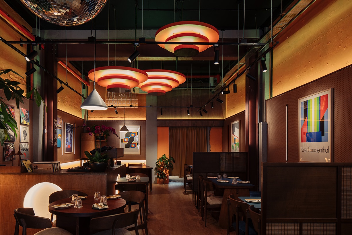 Interior of Offtrack Singapore, a retro-inspired vinyl bar and restaurant with mid-century decor, disco balls, graphic art, and ambient lighting, eclectic dining and nightlife venue.