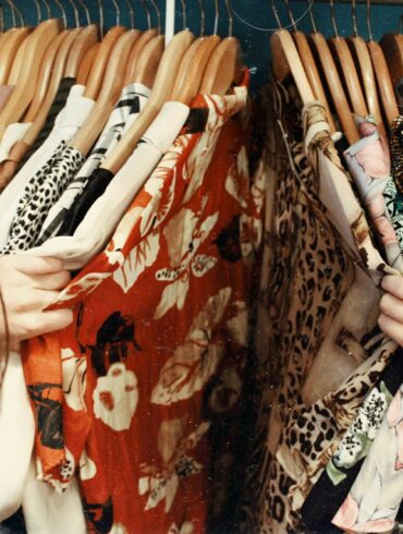 A woman going through clothes hanged in a thriftshop