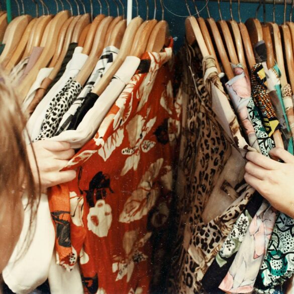 A woman going through clothes hanged in a thriftshop