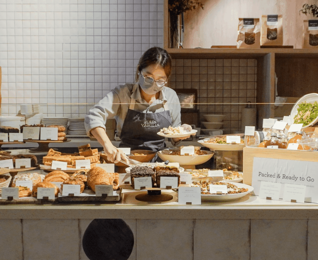 A service staff at Plain Vanilla organising the display of the pastries at the counter