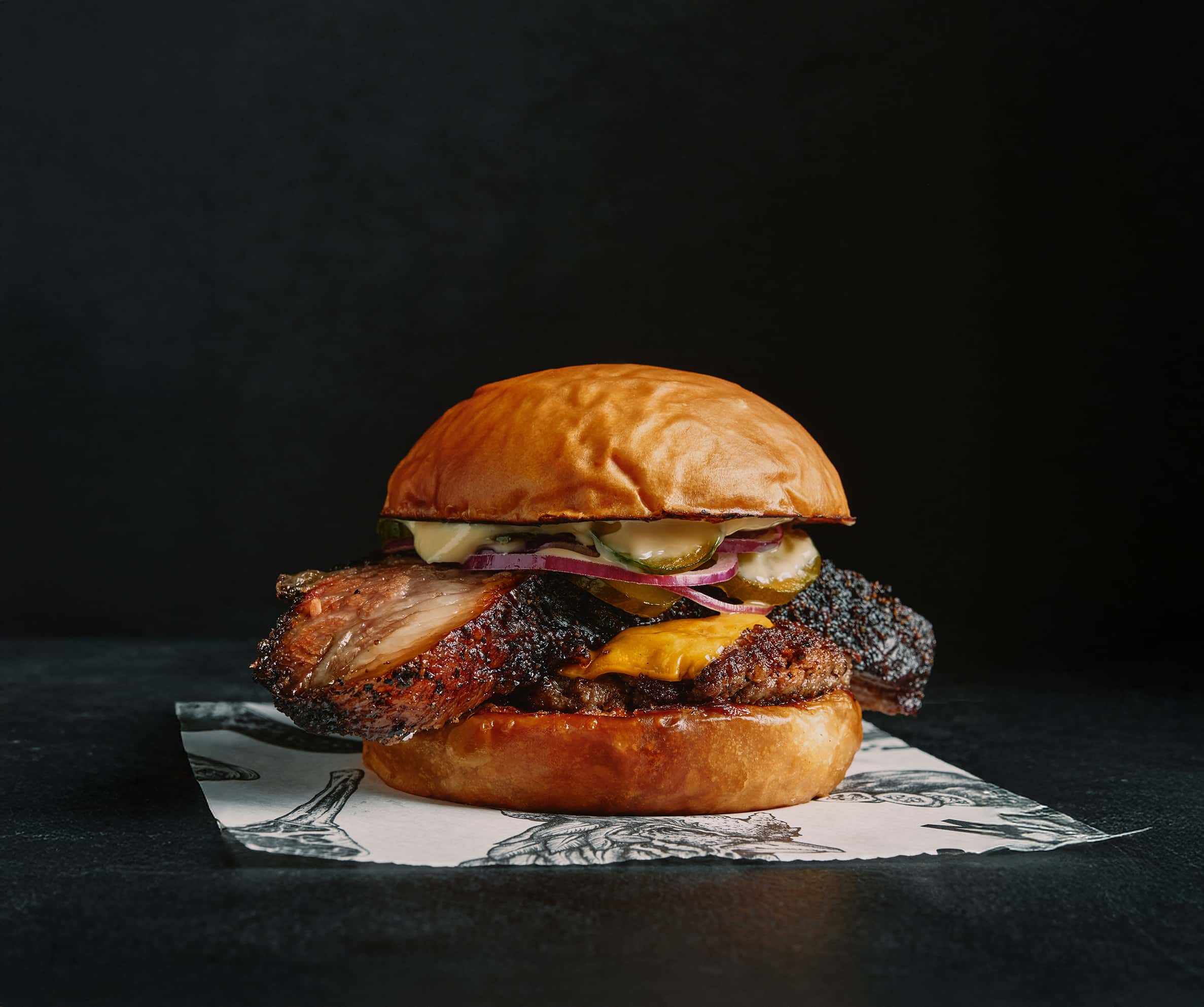 Signature smoked brisket burger with cheddar, pickles, and toasted bun from Meatsmith Singapore in Telok Ayer.
