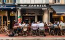 Lively outdoor dining scene at Sarnies café on Telok Ayer Street, Singapore, with diners seated at wooden tables against a backdrop of heritage shophouses.