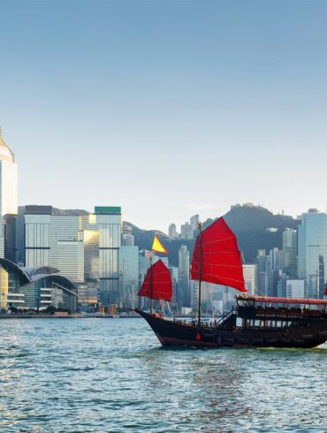 Traditional Chinese sailing ship in Victoria harbour in Hong Kong at evening