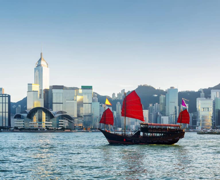 Traditional Chinese sailing ship in Victoria harbour in Hong Kong at evening