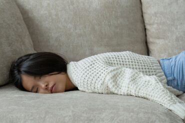 young asian girl sleeping on the couch