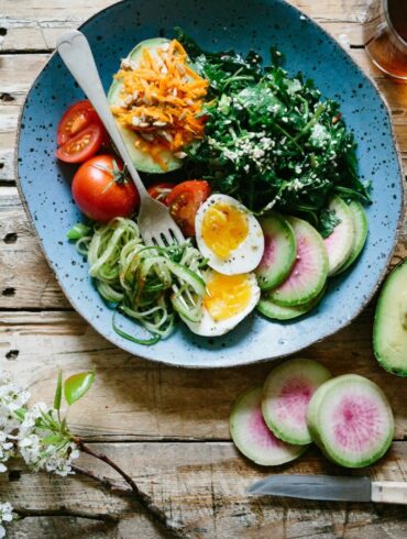 a photo of a healthy salad with fresh vegetables, drizzled with sesame oil, rice vinegar