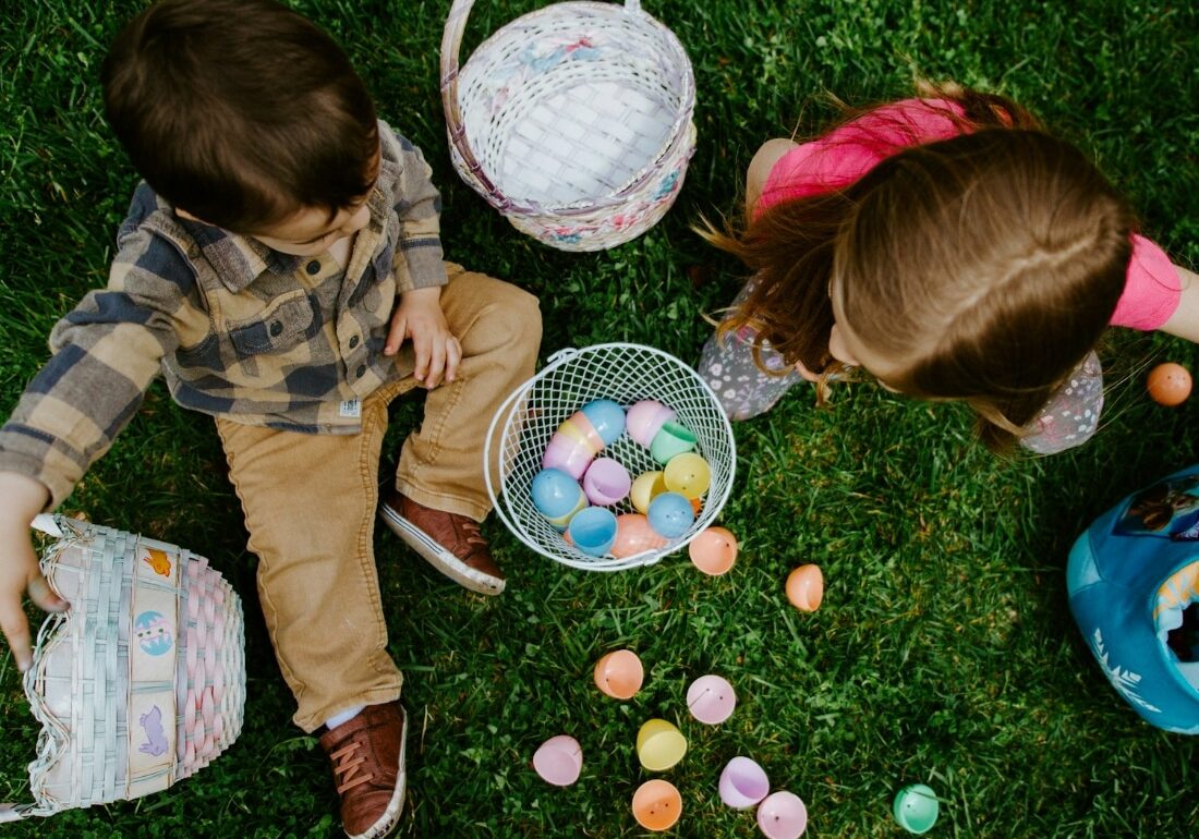 a photo of two children playing with eggs hunting on Easter