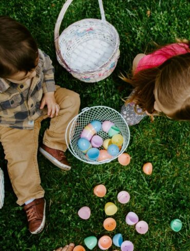 a photo of two children playing with eggs hunting on Easter