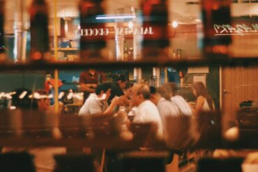 a photo of people dining in a restaurant through the window glass
