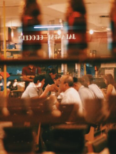 a photo of people dining in a restaurant through the window glass
