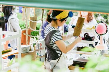 a photo of a Japanese woman tending to her stall at Higashi Betsuin Kurashi Morning Market in Nagoya, Japan