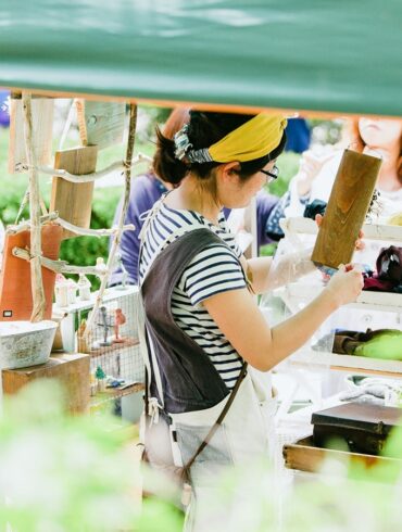 a photo of a Japanese woman tending to her stall at Higashi Betsuin Kurashi Morning Market in Nagoya, Japan