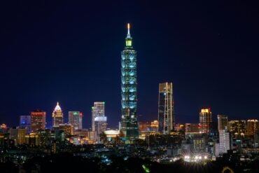 Free Illuminated Taipei 101 and city skyline at night showcasing modern urban architecture. Stock Photo