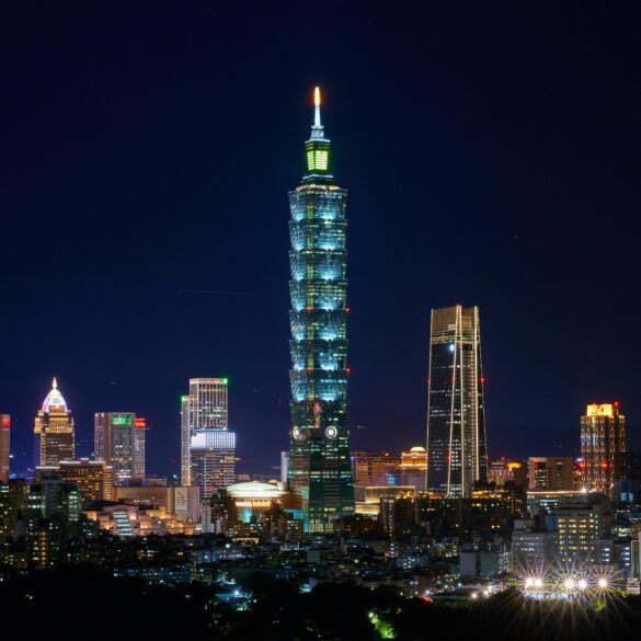 Free Illuminated Taipei 101 and city skyline at night showcasing modern urban architecture. Stock Photo