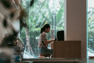 Woman working on laptop in a café—ideal remote work spot for digital nomads with natural light and quiet ambiance