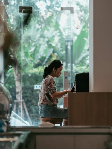 Woman working on laptop in a café—ideal remote work spot for digital nomads with natural light and quiet ambiance