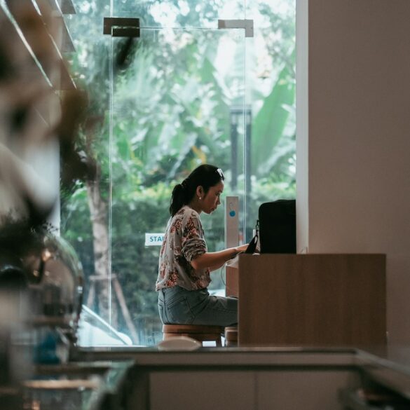 Woman working on laptop in a café—ideal remote work spot for digital nomads with natural light and quiet ambiance