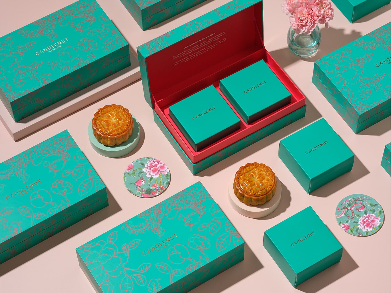 Candlenut’s bespoke Peranakan-inspired mooncake gift set featuring teal boxes with gold floral motifs, lotus mooncakes, and Tok Panjang-style presentation.