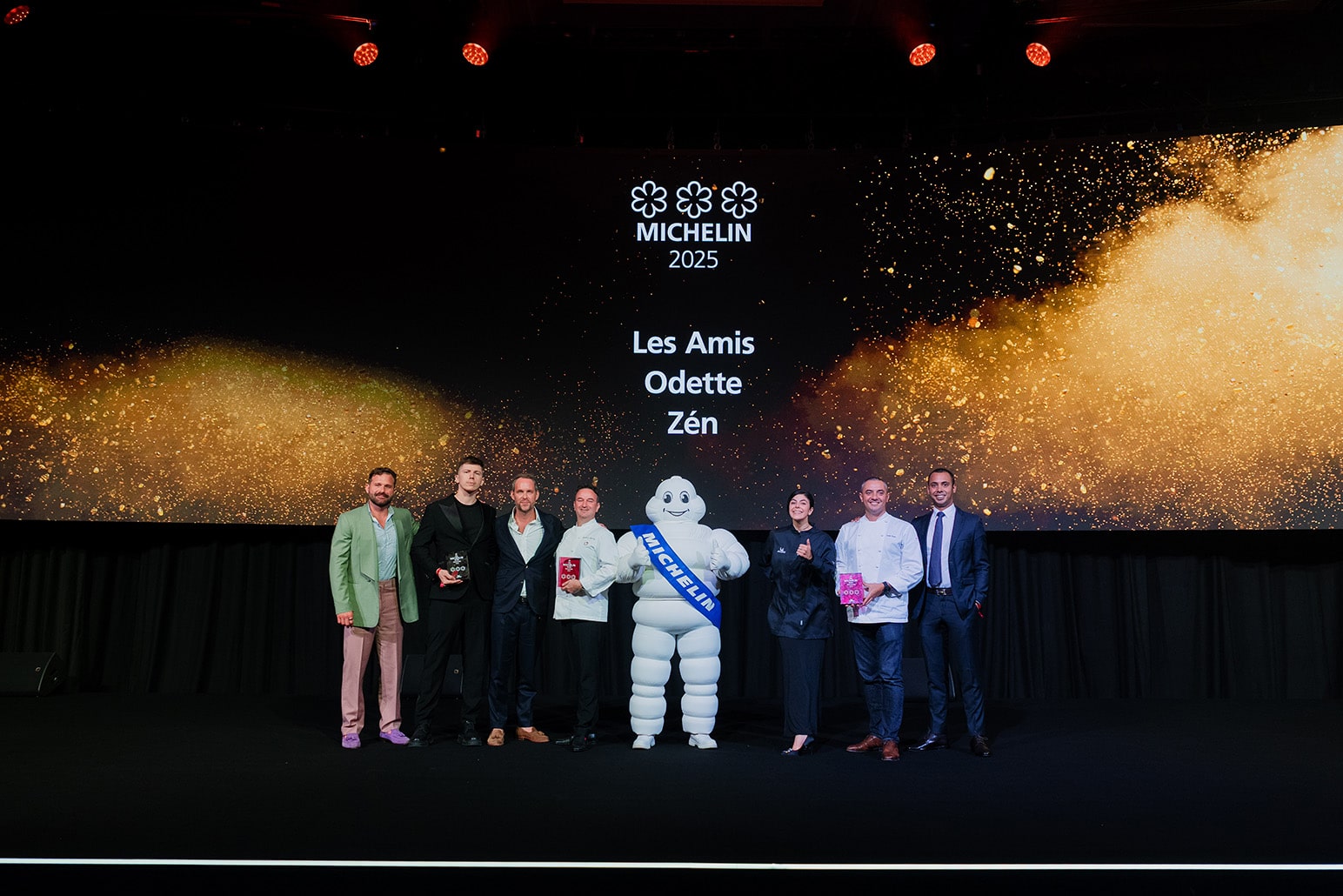 Chefs and representatives from Les Amis, Odette, and Zén at the Michelin Guide Singapore 2025 ceremony, celebrating their three Michelin stars on stage.