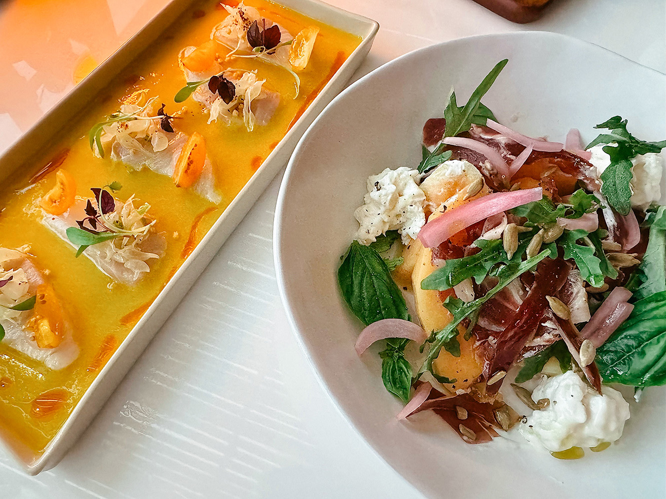Mediterranean small plates at Pastel Bangkok rooftop — Hamachi ceviche with citrus dressing and a melon & Iberico salad with arugula, cheese, and pickled onions.