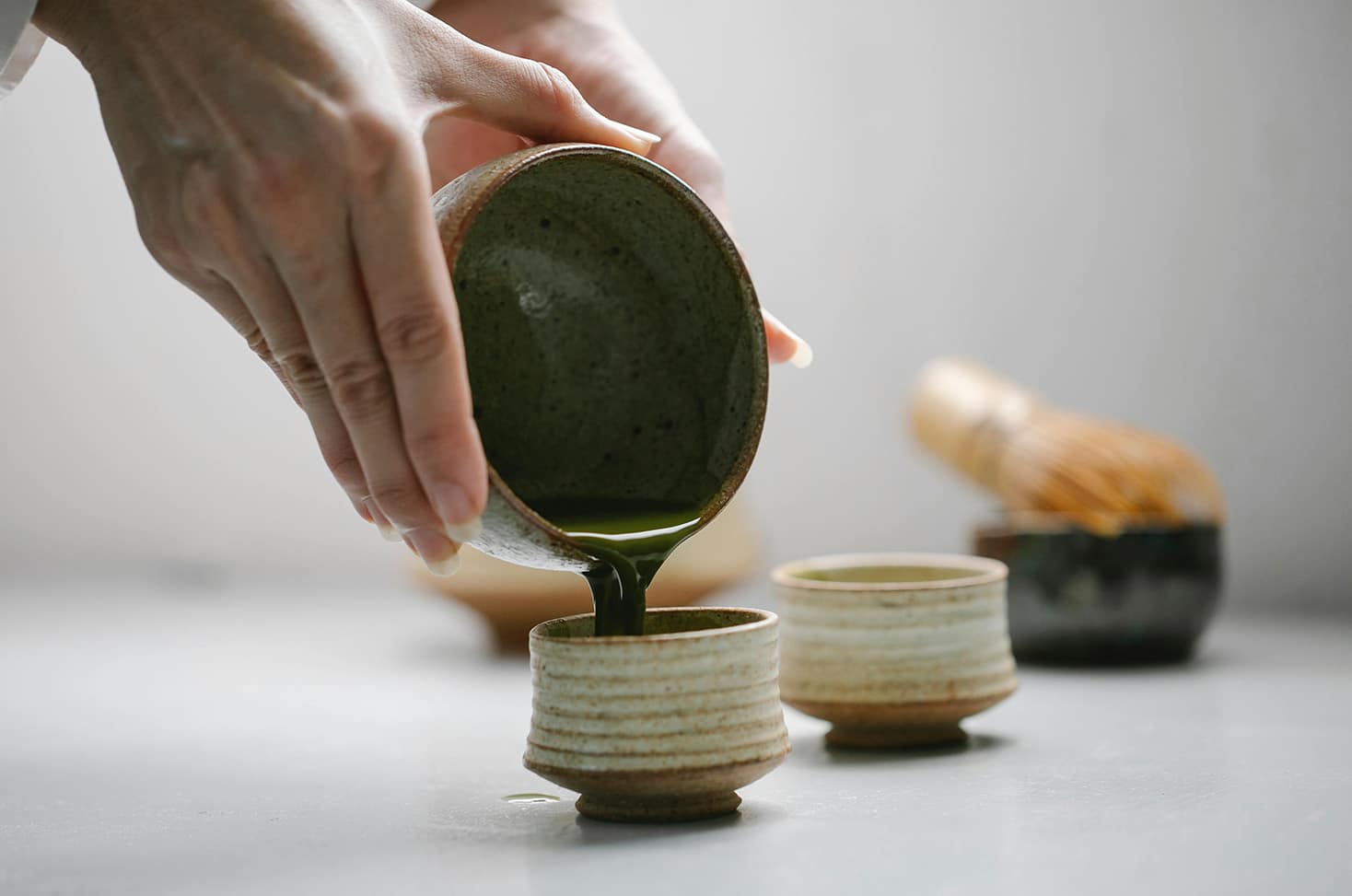 Traditional Japanese tea ceremony with matcha being poured into ceramic cups at Amanohashidate, Kyoto.