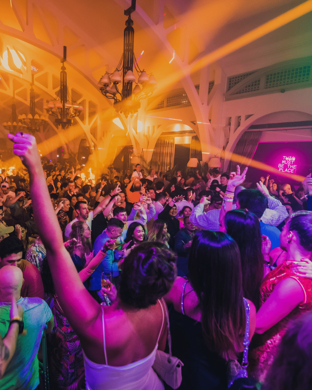 Partygoers at Amber Lounge, the official Formula 1 afterparty in Singapore, dancing under dramatic lighting at Clifford Pier.