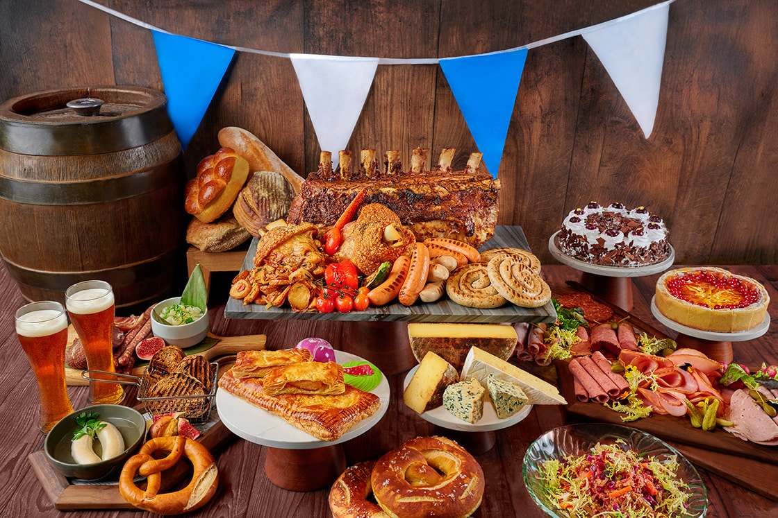 Oktoberfest 2025 buffet spread at Edge, Pan Pacific Singapore featuring Bavarian pork knuckle, sausages, pretzels, Black Forest cake, German cheeses, charcuterie, and festive beers.