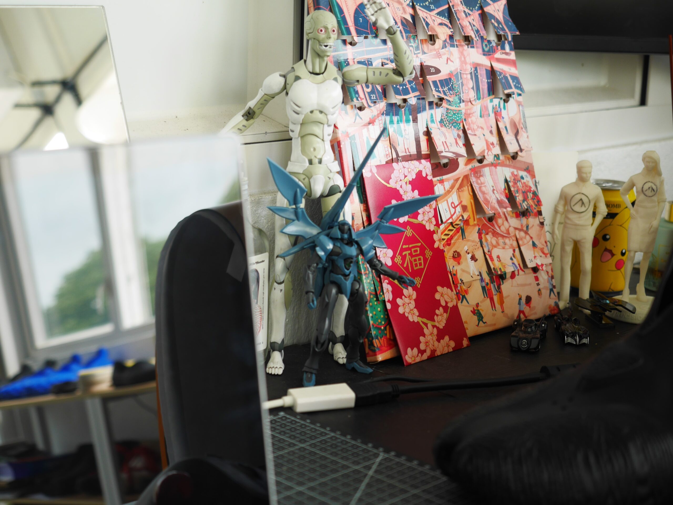 A work desk with 3D printed action figures and comic vehicles