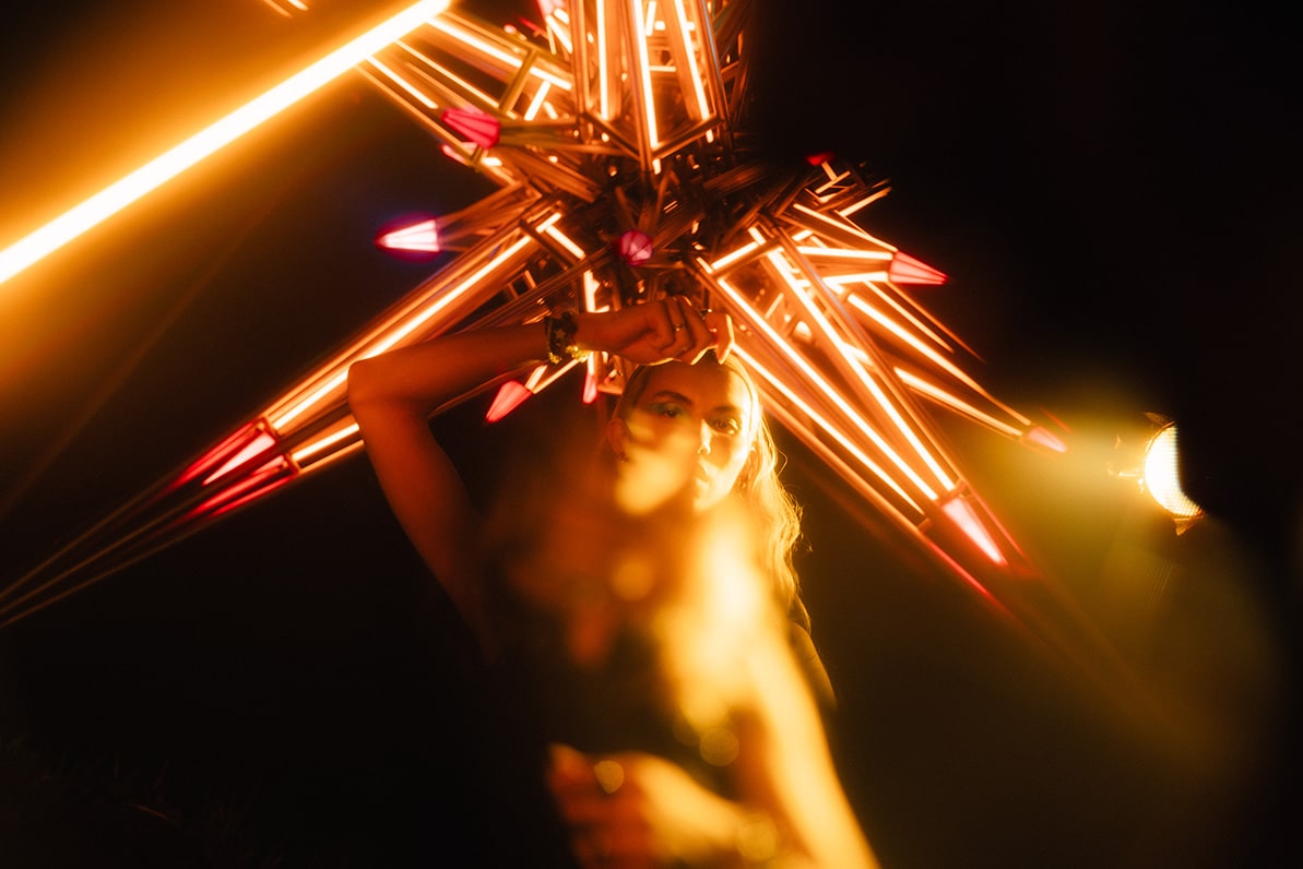 Sunset party at NOVA rooftop bar during F1 Singapore 2025, hosted by Aperol Spritz, featuring skyline views and glowing orange décor.