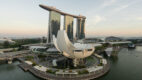 Aerial view of Marina Bay Sands and the ArtScience Museum framed against the Singapore skyline at sunset.