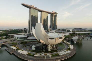 Aerial view of Marina Bay Sands and the ArtScience Museum framed against the Singapore skyline at sunset.