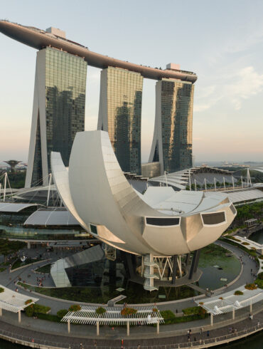 Aerial view of Marina Bay Sands and the ArtScience Museum framed against the Singapore skyline at sunset.